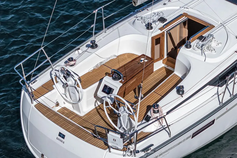 Slide: The Image of 2024 Bavaria Cruiser 34 sailboat with dual steering wheels and teak deck. - 13