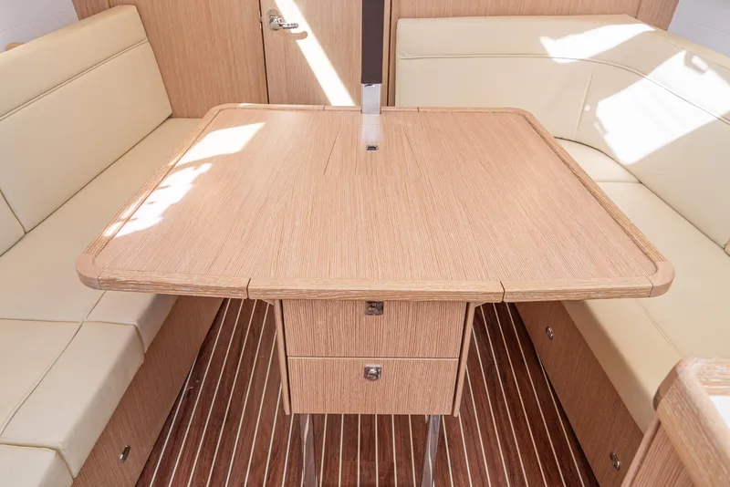 Slide: The Image of Interior of 2024 Bavaria Cruiser 34 yacht with wooden table and beige seating. - 26