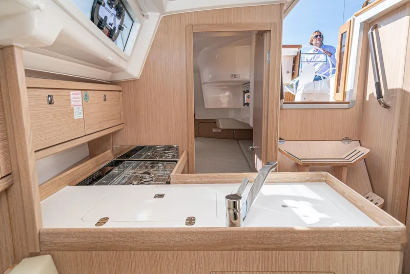 Slide: The Image of Interior of 2024 Bavaria Cruiser 34 yacht, featuring modern kitchen and wooden cabinetry. - 33