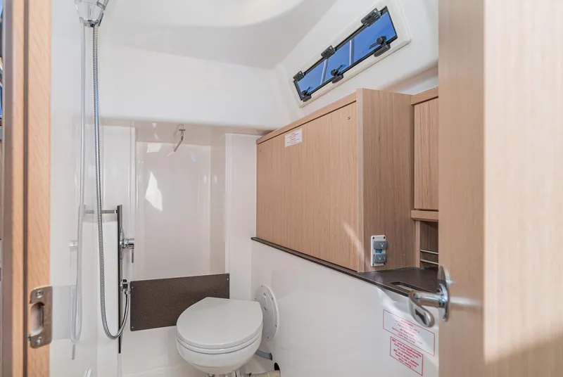 Slide: The Image of 2024 Bavaria Cruiser 34 yacht bathroom with modern fixtures and wood cabinetry. - 40