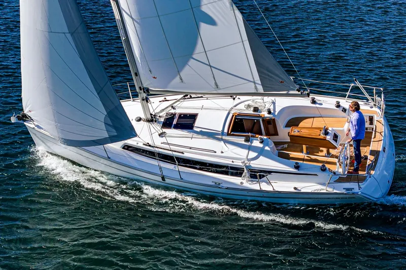 Slide: The Image of 2024 Bavaria Cruiser 34 sailing on open water, elegant design, white sails. - 8
