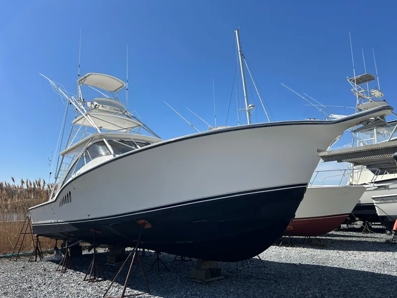 Slide: The Image of 2002 Albemarle 410 Express Fisherman boat on gravel, clear sky background. - 1