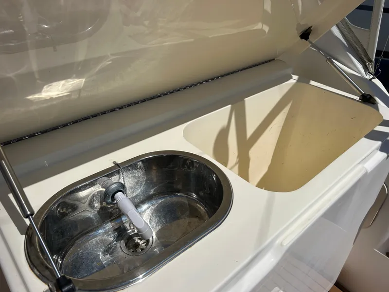 Slide: The Image of 2002 Albemarle 410 Express Fisherman boat sink and storage compartment. - 11