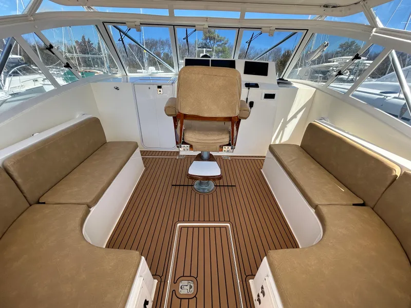 Slide: The Image of 2002 Albemarle 410 Express Fisherman interior with helm chair and cushioned seating. - 12