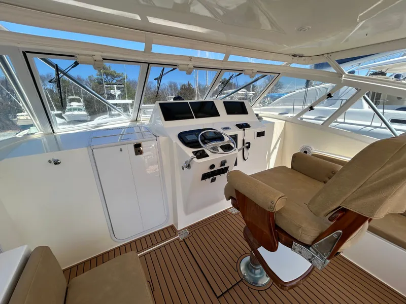 Slide: The Image of 2002 Albemarle 410 Express Fisherman helm with captain's chair and navigation controls. - 14
