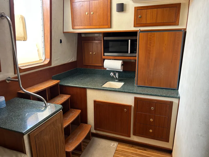 Slide: The Image of 2002 Albemarle 410 Express Fisherman interior kitchen with wooden cabinets and modern appliances. - 20