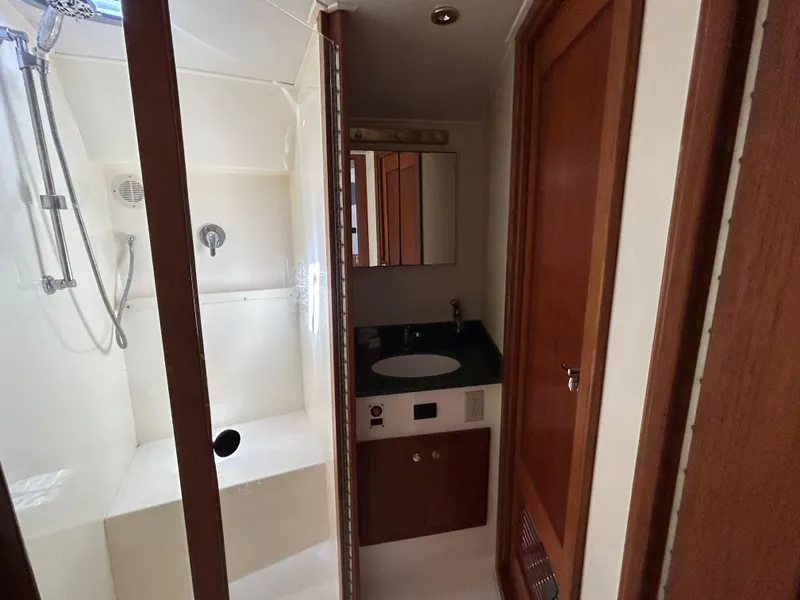 Slide: The Image of 2002 Albemarle 410 Express Fisherman bathroom with shower, sink, and wooden cabinetry. - 26