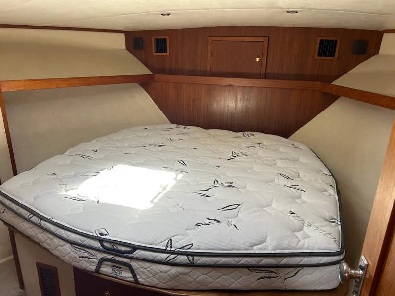 Slide: The Image of 2002 Albemarle 410 Express Fisherman cabin with a comfortable bed and wooden interior. - 28