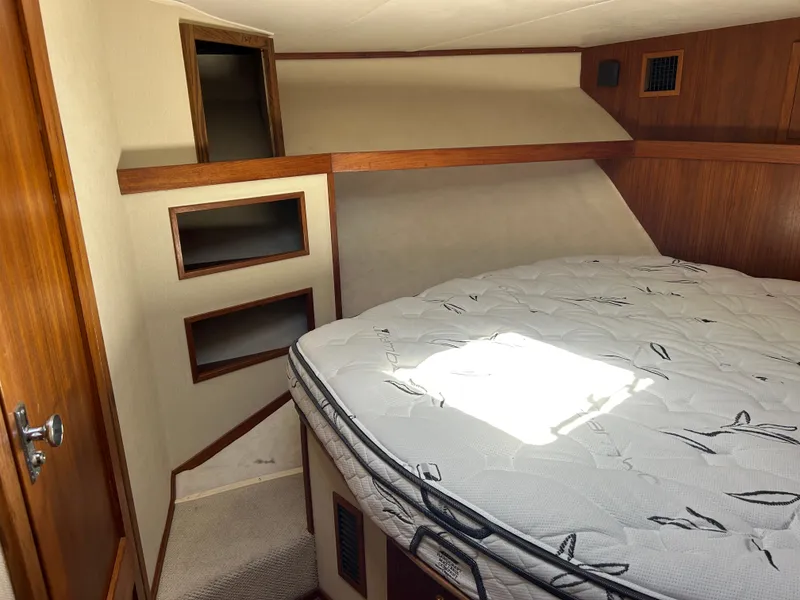 Slide: The Image of 2002 Albemarle 410 Express Fisherman cabin with bed and wooden storage shelves. - 29