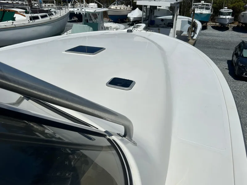 Slide: The Image of 2002 Albemarle 410 Express Fisherman boat deck with hatches, docked among other boats. - 35