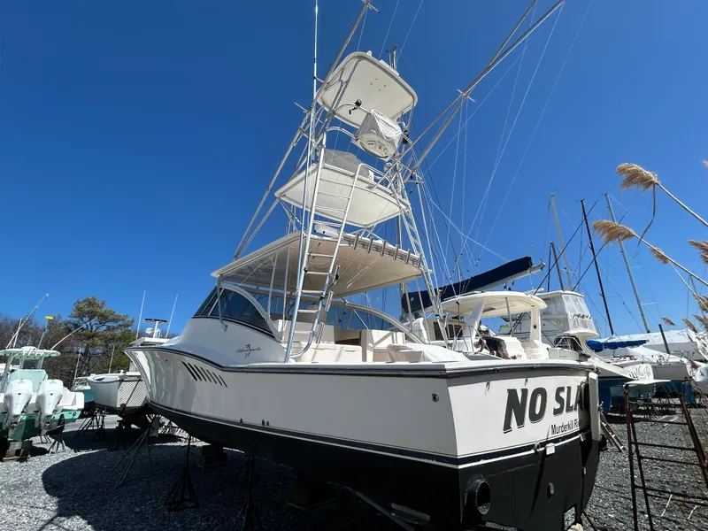 Slide: The Image of 2002 Albemarle 410 Express Fisherman boat with tower, docked under clear blue sky. - 4