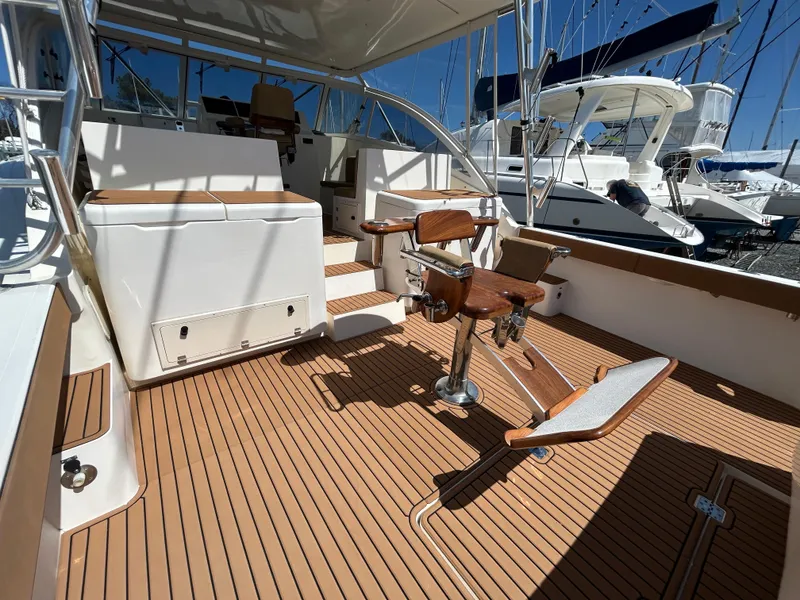 Slide: The Image of 2002 Albemarle 410 Express Fisherman boat deck with fishing chair and teak flooring. - 8