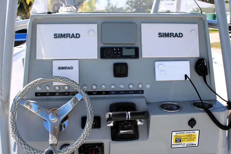 Slide: The Image of Boat dashboard with Simrad electronics, steering wheel, and controls, Release 240 RX, 2020 model. - 13