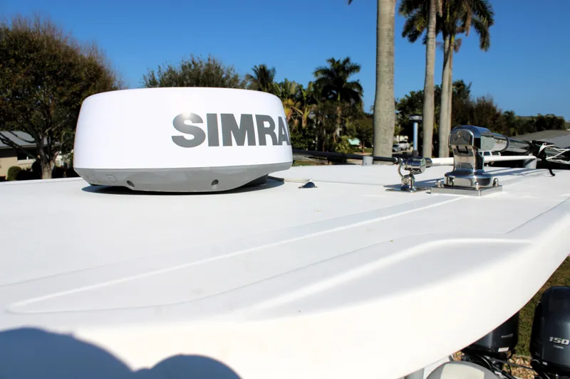 Slide: The Image of 2020 Release 240 RX boat with Simrad radar on deck, surrounded by palm trees. - 26
