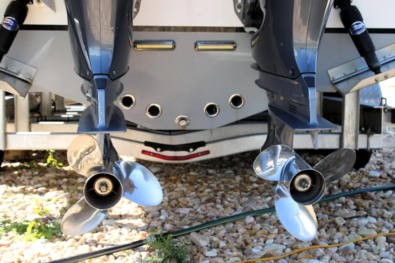 Slide: The Image of Twin outboard motors on a 2020 Release 240 RX boat, resting on gravel. - 28