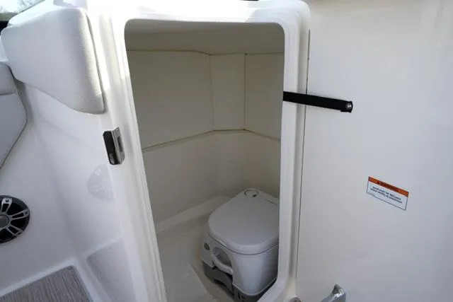 Slide: The Image of 2025 Sea Ray SPX 230 boat interior with compact marine toilet. - 12