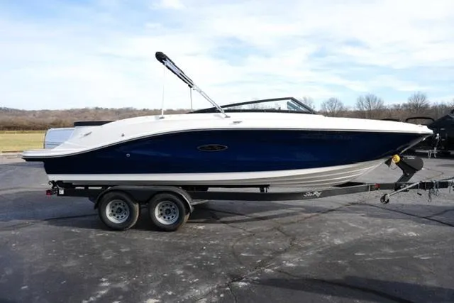 Slide: The Image of 2025 Sea Ray SPX 230 boat on trailer, blue and white design, parked outdoors. - 3