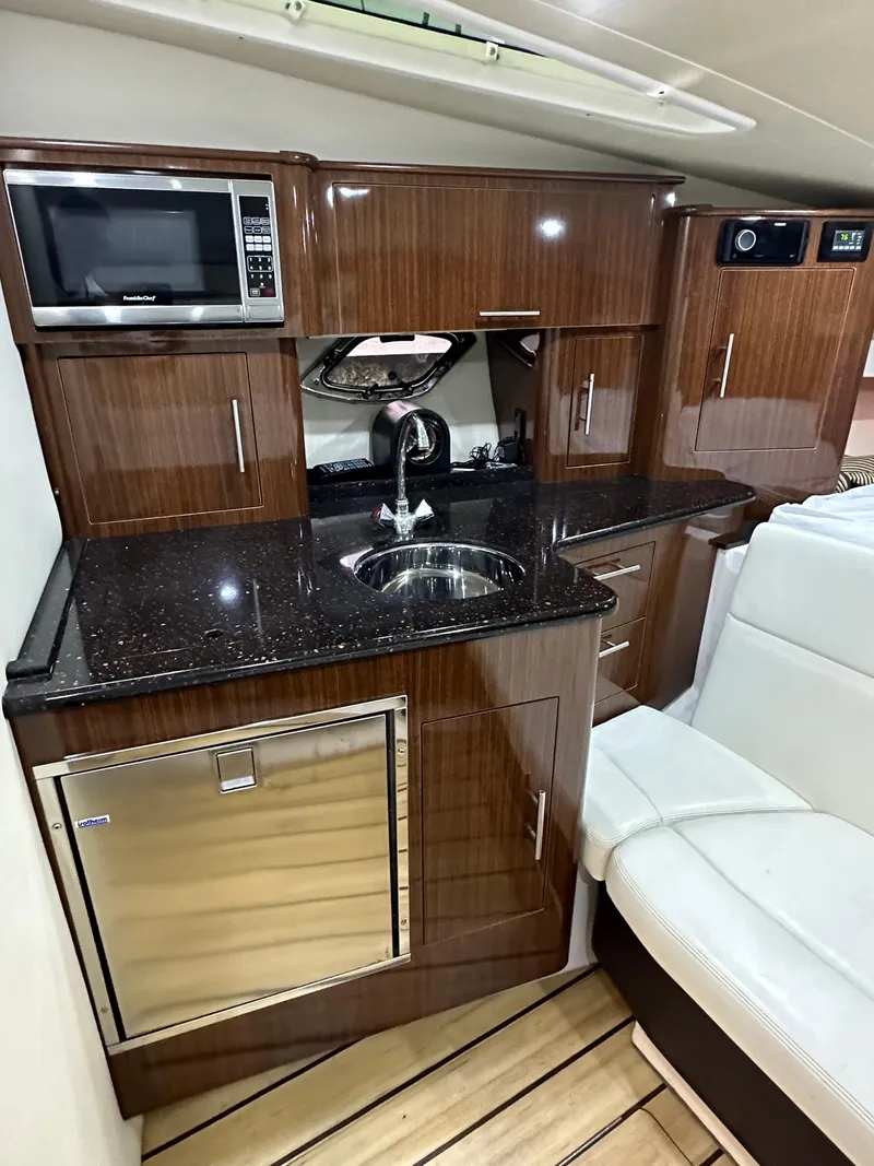 Slide: The Image of Interior of 2014 Regal 35 Sport Coupe with modern kitchenette and sleek wood finish. - 11