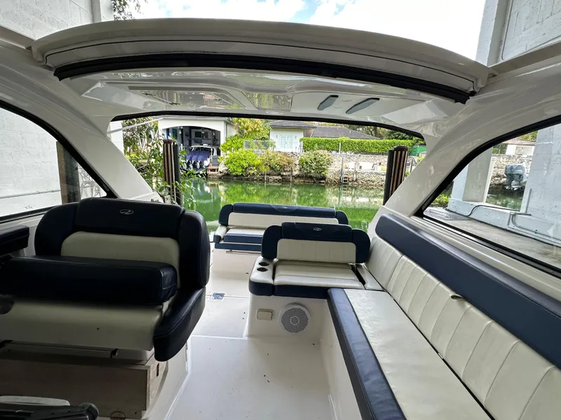 Slide: The Image of 2014 Regal 35 Sport Coupe interior with spacious seating and open sunroof, docked by a serene canal. - 14