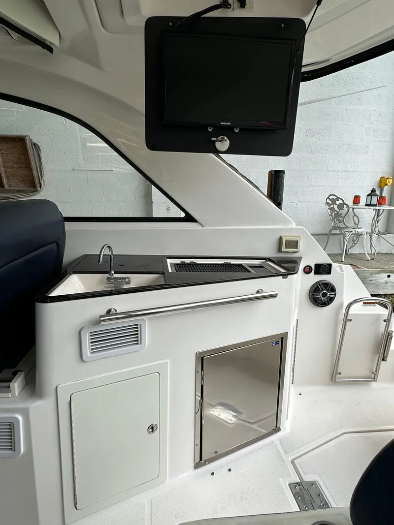Slide: The Image of 2014 Regal 35 Sport Coupe interior with kitchenette and mounted TV. - 15