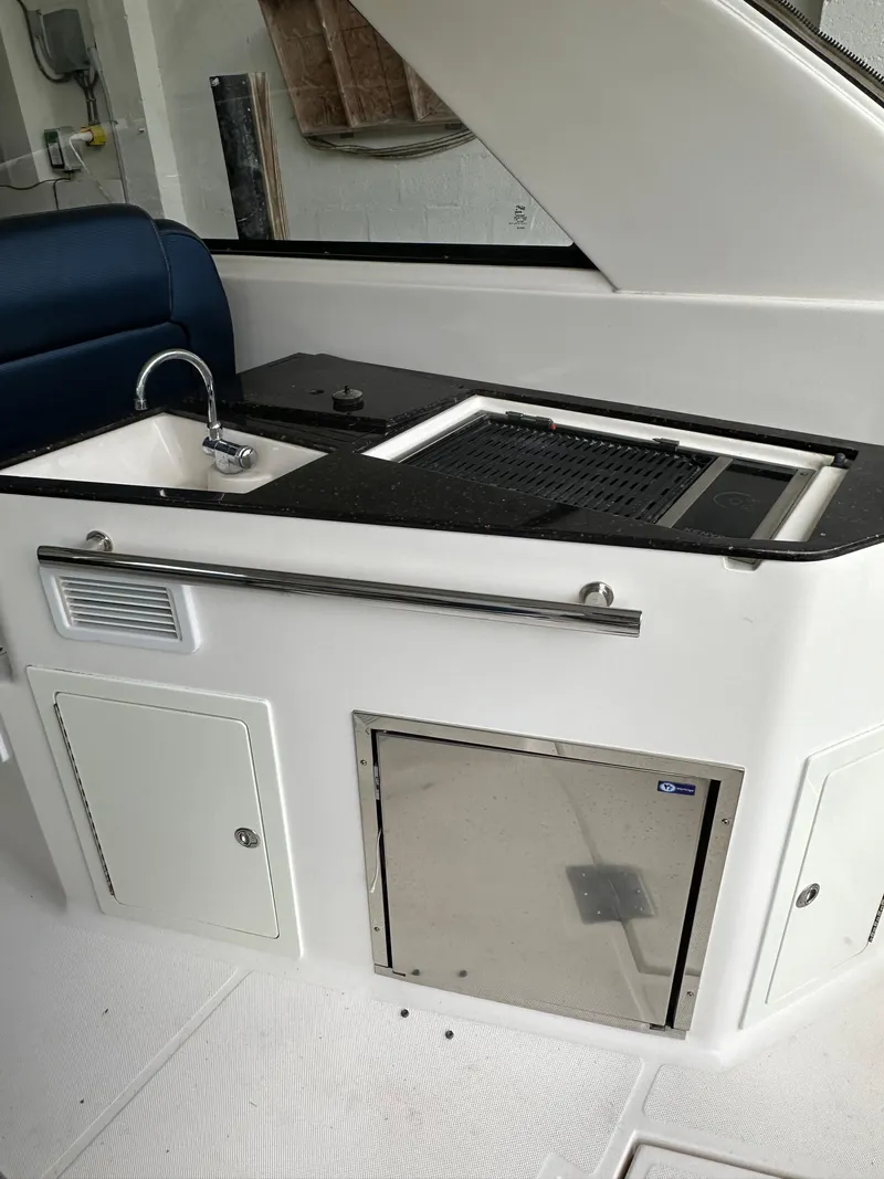 Slide: The Image of 2014 Regal 35 Sport Coupe kitchenette with sink, grill, and storage. - 16