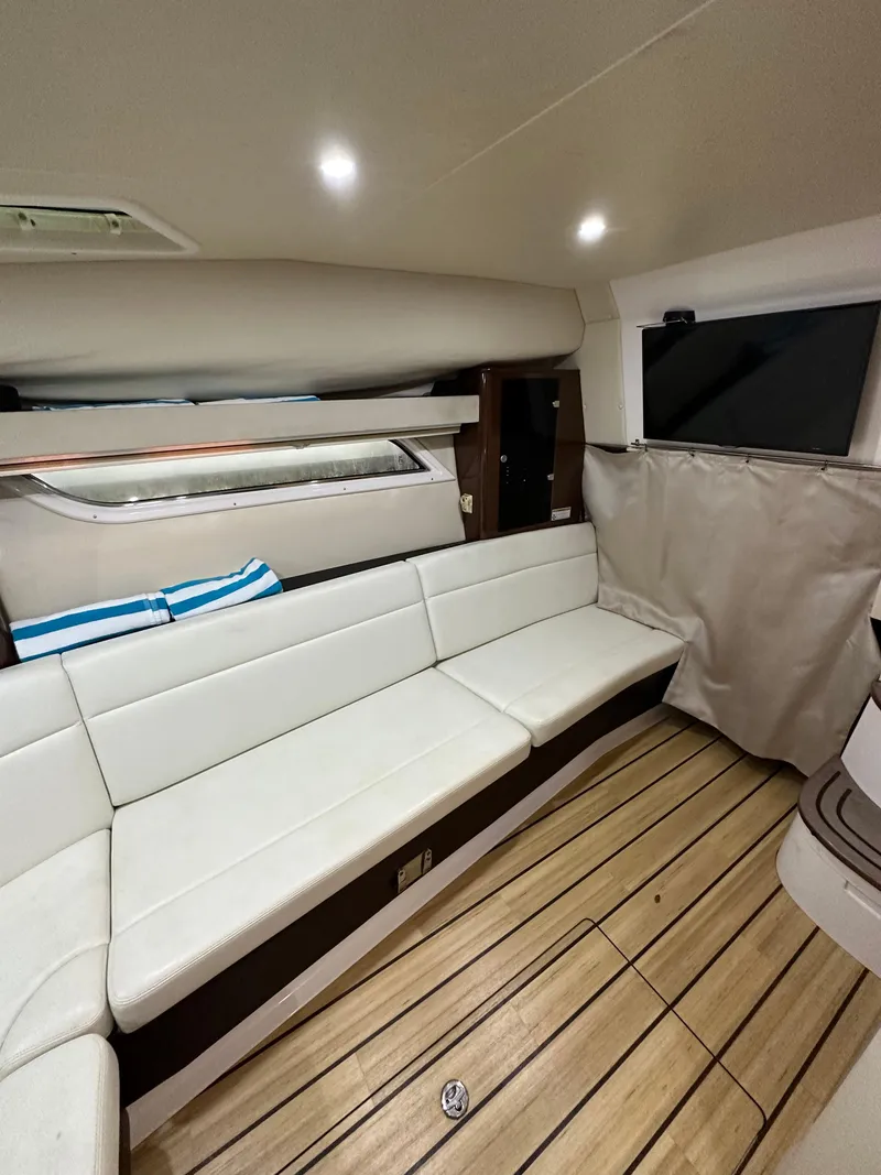 Slide: The Image of 2014 Regal 35 Sport Coupe interior with white seating and wooden flooring. - 6