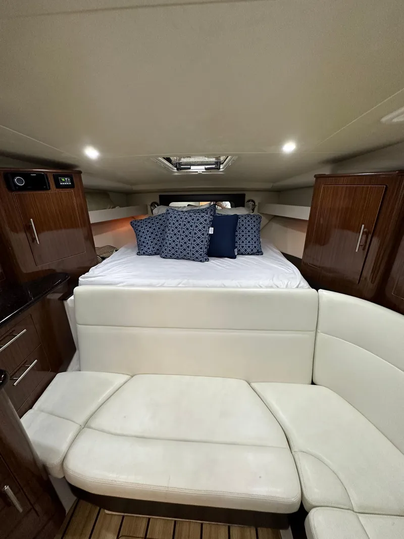 Slide: The Image of 2014 Regal 35 Sport Coupe interior with bed, seating, and wooden cabinets. - 7
