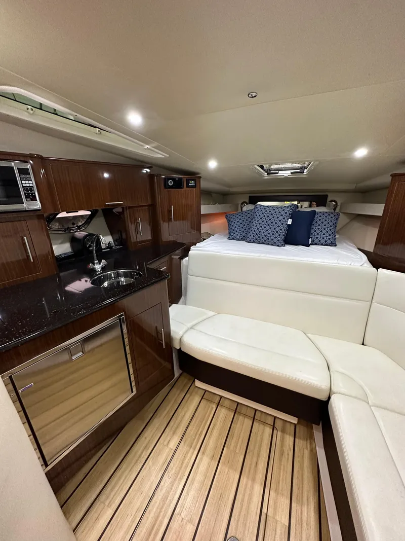 Slide: The Image of 2014 Regal 35 Sport Coupe interior with kitchenette, seating, and bed. Luxurious yacht cabin design. - 8