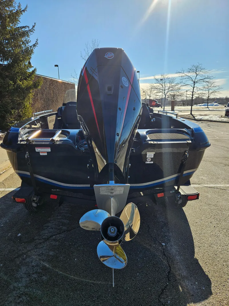 Slide: The Image of 2025 Nitro ZV19 boat, rear view with outboard motor, parked outdoors. - 5