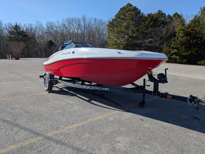 Slide: The Image of 2025 Tahoe T16 boat on trailer in parking lot, surrounded by trees. - 1