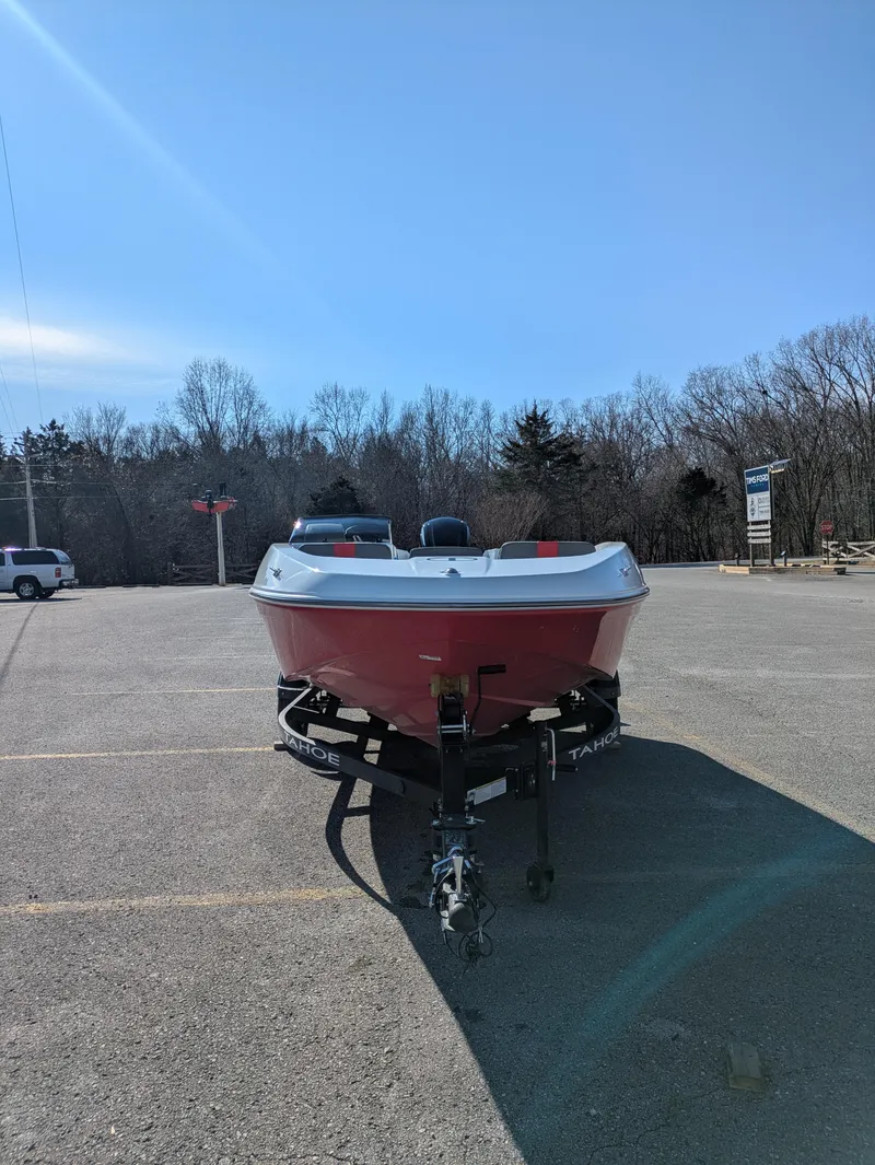 Slide: The Image of 2025 Tahoe T16 boat on trailer in parking lot under clear blue sky. - 2