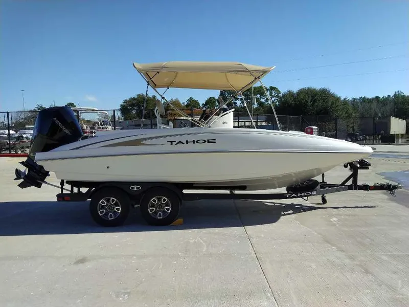 Slide: The Image of 2025 Tahoe 2150 CC boat on trailer with canopy, parked outdoors. - 1