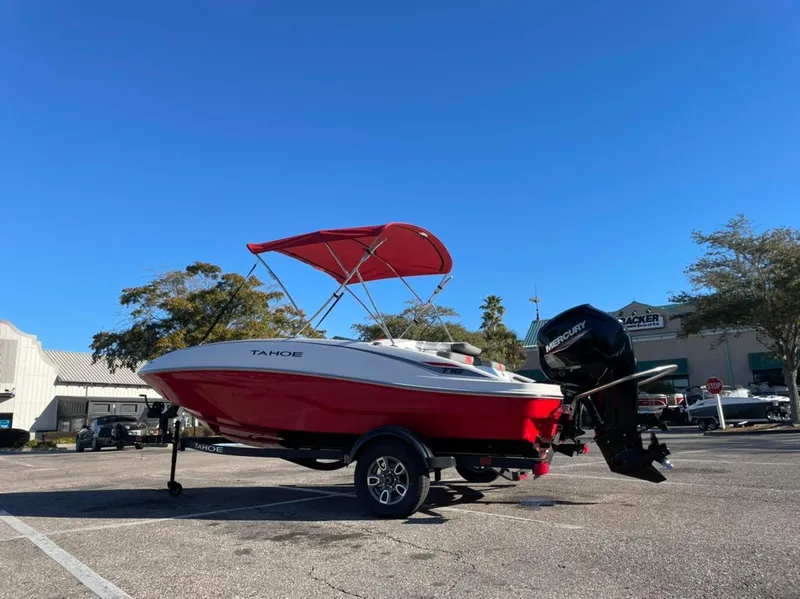The Image of 2025 Tahoe T16 boat with red canopy and outboard motor in parking lot. - 0