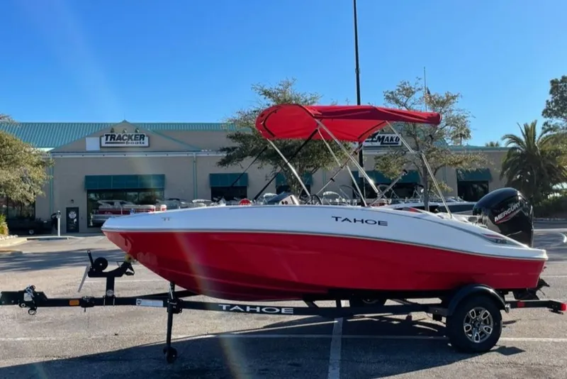 Slide: The Image of 2025 Tahoe T16 boat with red hull and canopy on trailer, parked outdoors. - 4