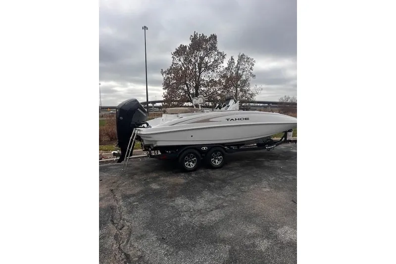 Slide: The Image of 2025 Tahoe 2150 CC boat on trailer, parked outdoors under cloudy sky. - 118