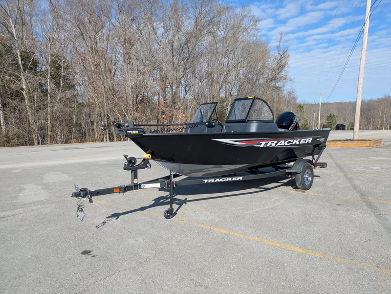 Slide: The Image of 2025 Tracker Pro Guide V-16 WT boat on trailer in parking lot. - 2