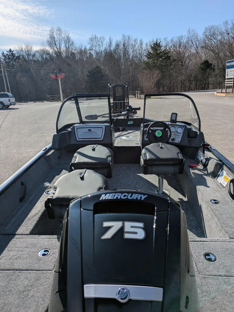 Slide: The Image of 2025 Tracker Pro Guide V-16 WT boat with Mercury 75 engine, parked outdoors. - 5