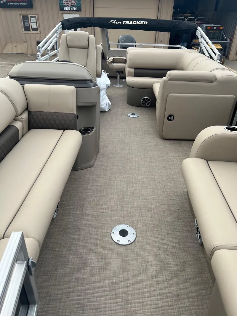 Slide: The Image of 2025 Sun Tracker SportFish 22 DLX pontoon boat interior with beige seating and carpeted floor. - 4