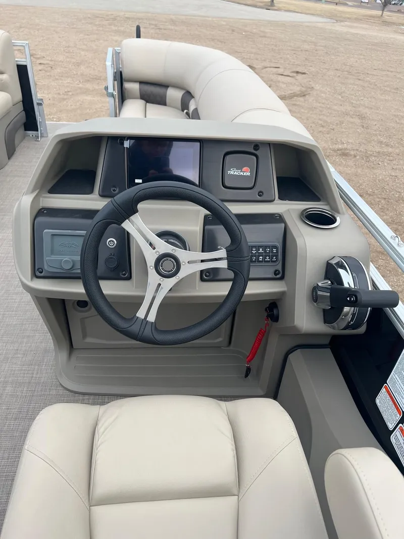 Slide: The Image of 2025 Sun Tracker SportFish 22 DLX boat interior with steering wheel and control panel. - 6
