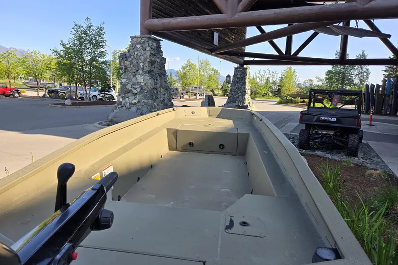 Slide: The Image of 2025 Tracker Grizzly 1650 T Prairie Wings Edition boat displayed outdoors near a Tracker vehicle. - 5