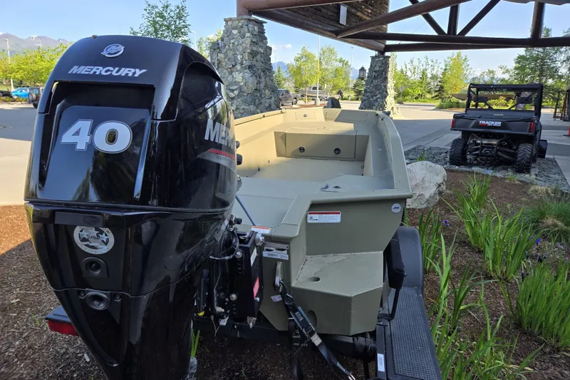 Slide: The Image of 2025 Tracker Grizzly 1650 T Prairie Wings Edition with Mercury 40 engine, parked outdoors. - 4