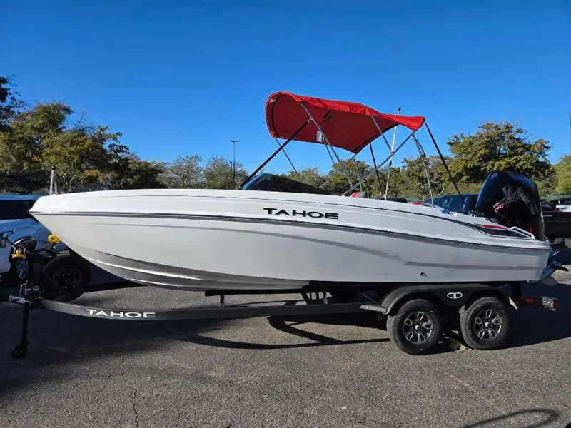 The Image of 2025 Tahoe T21 boat with red canopy on trailer, parked outdoors. - 0