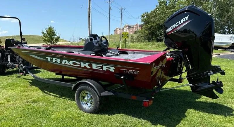 Slide: The Image of 2024 Tracker Pro Team 175 TF boat with Mercury engine on grassy area. - 2