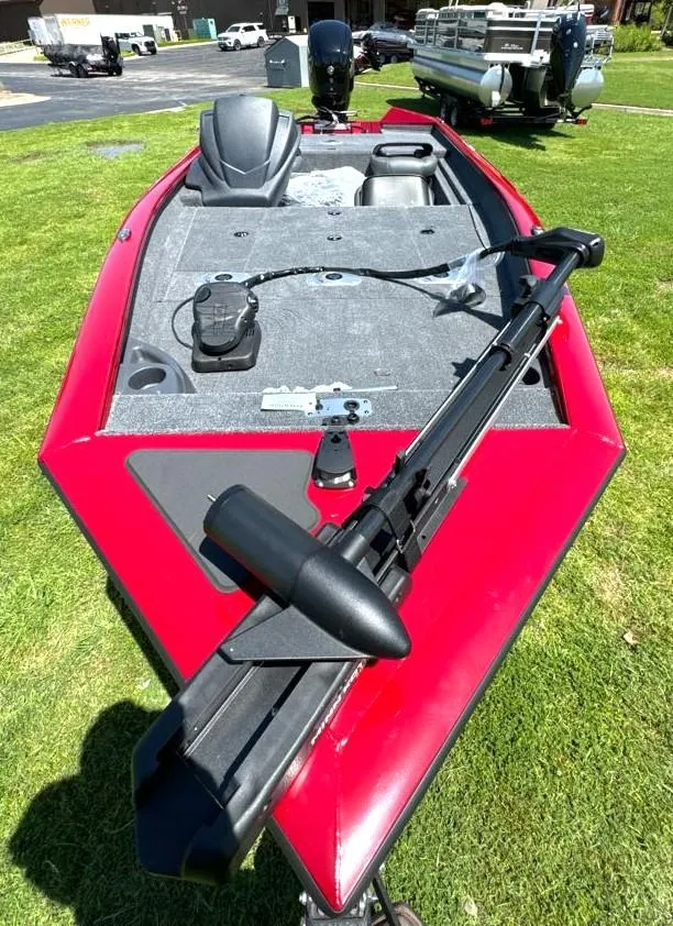 Slide: The Image of 2024 Tracker Pro Team 175 TF boat, red exterior, on grass, featuring a trolling motor. - 6