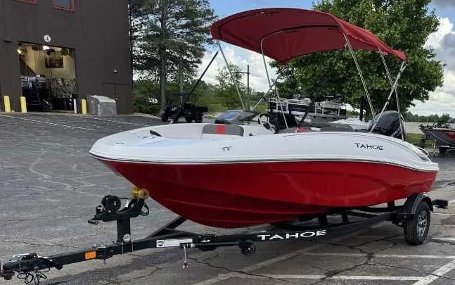 Slide: The Image of 2025 Tahoe T16 boat with red hull and canopy on a trailer in a parking lot. - 2