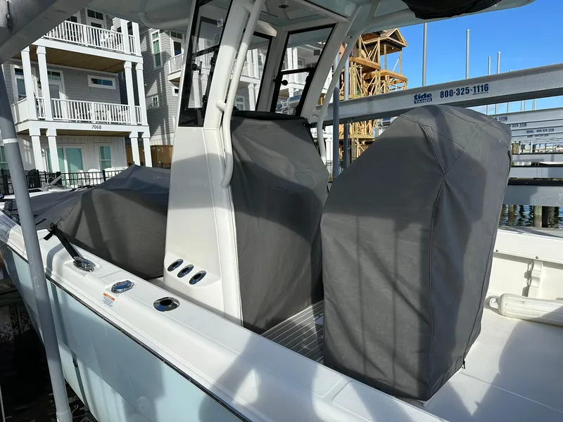Slide: The Image of 2022 World Cat 235 CC boat with covered seats, docked near waterfront homes. - 21