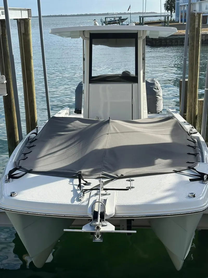 Slide: The Image of 2022 World Cat 235 CC boat docked, featuring a covered bow and sleek design. - 22