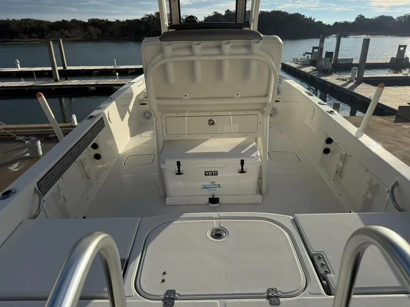Slide: The Image of 2022 World Cat 235 CC boat interior at dock, featuring spacious deck and seating. - 6