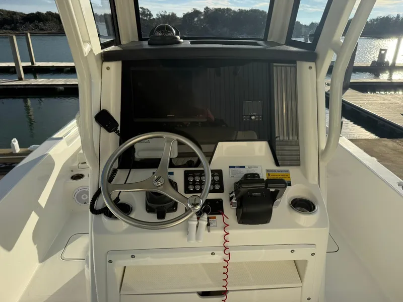 Slide: The Image of 2022 World Cat 235 CC boat dashboard with steering wheel and controls. - 7