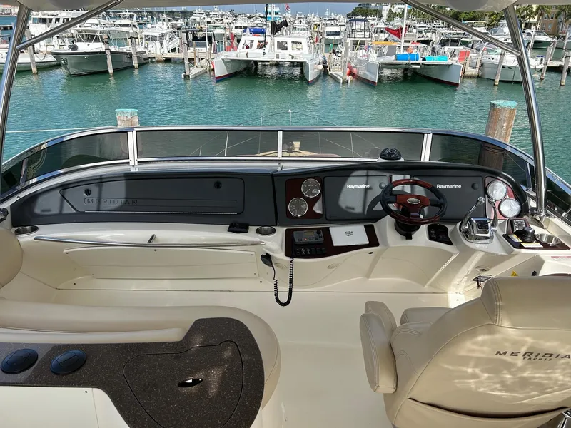 Slide: The Image of Meridian 441 yacht helm, 2013 model, overlooking marina with multiple boats docked. - 6